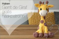 a crocheted giraffe sitting on top of a wooden table next to a heart