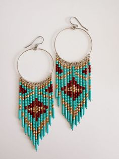 Introducing our Zuri Beaded Earrings. Crafted with hypoallergenic stainless steel posts, these earrings are gold dipped and hand beaded with turquoise, maroon and golden beads. The unique design makes them light on the ears. Add a touch of elegance to any outfit with these expertly crafted earrings. Wire Earrings Beads, Small Beaded Earrings, Hoop Earrings Indian, Native American Beadwork Earrings, Indigenous Beaded Earrings, Bead Jewelry Patterns, Wire Jewerly, Crafted Earrings, Seed Bead Jewelry Patterns