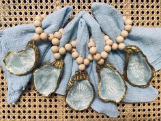 an assortment of seashells and wooden beads on a blue cloth with gold accents