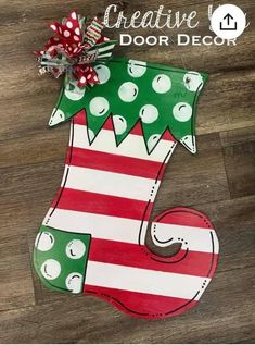 a wooden christmas stocking with the words creative you door decor painted on it's side