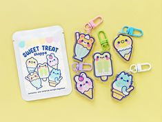 some cute little clip clips on top of a yellow table next to a bag with the words sweet treat shoppe written on it