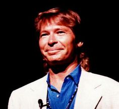 a man wearing a white jacket and blue shirt