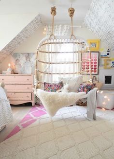 a bedroom with a hanging bed and white rugs on the floor in front of it