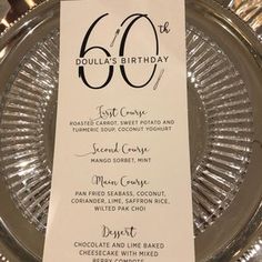 a silver plate with a black and white table number on it's side that says 60 th birthday