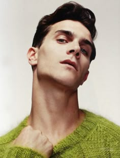 a man in a green sweater looking up