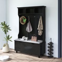 an entryway with a bench, coat rack and potted plant