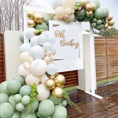 a bunch of balloons that are in the shape of a tree with gold and white balls