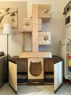 a cat house made out of wooden pallets in the corner of a living room