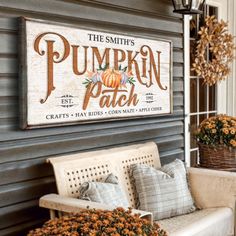 pumpkin patch sign hanging on the side of a building next to a bench with flowers