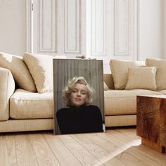 a photograph of marilyn monroe on the floor in front of a couch