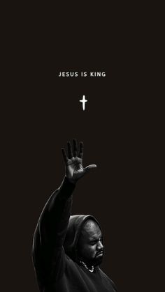 a black and white photo of a man holding his hands up in the air with jesus is king above him