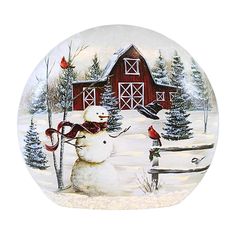 a plate with a snowman and bird on it in front of a red barn