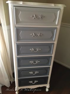 a white and gray dresser sitting next to a window