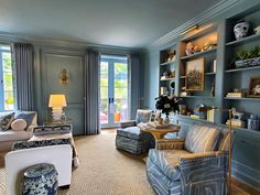 a living room filled with lots of furniture and decor on top of carpeted flooring