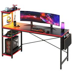 a computer desk with a large monitor and keyboard on it's side, next to a gaming console