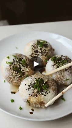 a white plate topped with meatballs and chopsticks