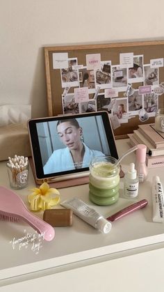 a table topped with cosmetics and personal care items next to a tablet computer screen showing a woman's face