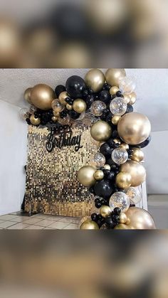 some black and gold balloons are hanging from the ceiling