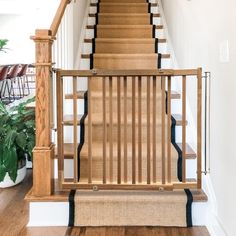 a staircase with wooden handrails and carpeted steps leading up to the second floor