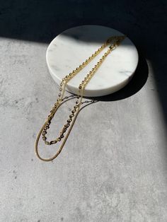 Instantly elevate any look with the double layer chain. Low effort with high impact for any outfit. Details Care Shipping 14K Gold Plated 14" and 16" Length with 2" extender Hypoallergenic, Lead Compliant Imported To keep your jewelry looking its best, store separately and wipe away dirt or oil buildup with a clean, soft cloth. Avoid contact with water, lotions, jewelry cleaners or other chemicals as as they may strip cause fading. We also recommend removing dainty necklaces before sleeping. Fre High Low Necklace, Dainty Bar Necklace, Number Necklace, Layered Chain Necklace, Layered Chains, Tourmaline Necklace, Jewelry Manufacturers, Classic Jewelry, Pearl Chain