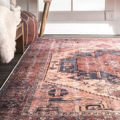 an antique rug is displayed in front of a window