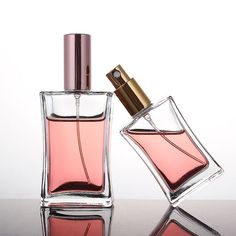 two perfume bottles sitting on top of a table