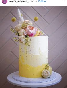 a white and yellow cake with flowers on top