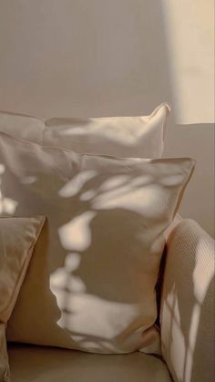 two pillows sitting on top of a white couch