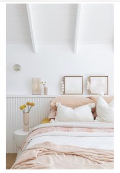 a bedroom with white walls and beige bedding