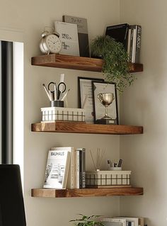 three wooden shelves with books and plants on them