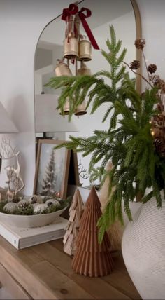 christmas decorations are displayed on a table in front of a mirror and other holiday items