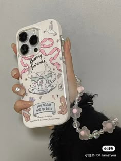 a woman holding up a phone case with an image of a coffee cup on it