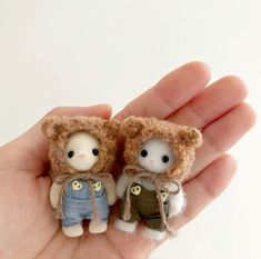 two small stuffed animals are in someone's hand