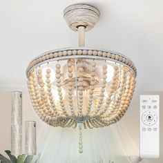 a chandelier with beads hanging from it's ceiling and a remote control