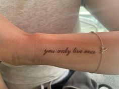 a woman's arm with the words you only live once tattooed on her left arm