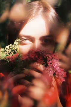 a woman holding flowers in front of her face