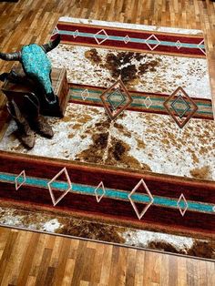 an elephant is sitting on a rug in the middle of a room with wood flooring