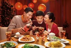 three people sitting at a table with plates of food and drinks in front of them