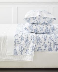 a bed with blue and white sheets on top of it