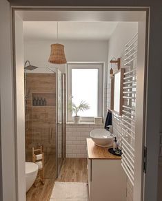 an open door leading to a bathroom with a sink and shower stall in it's center