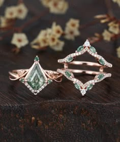 three different types of rings with diamonds and green stones on top of each other,