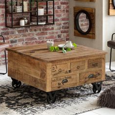 a wooden coffee table with drawers on wheels in front of a brick wall and rug