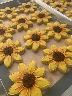 cookies decorated with yellow and brown sunflowers on a baking sheet