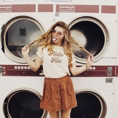 a woman standing in front of a stack of washers with her hands on her hips