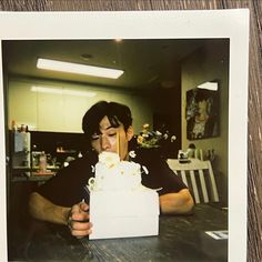 a man sitting at a table with a cake in front of him