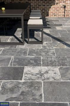 a table and two chairs sitting on top of a stone patio