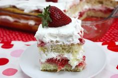 a piece of cake with white frosting and strawberries on top