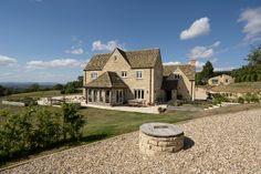 a large stone house sitting on top of a lush green field