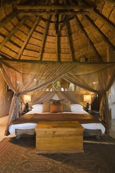 a large bed sitting under a wooden roof