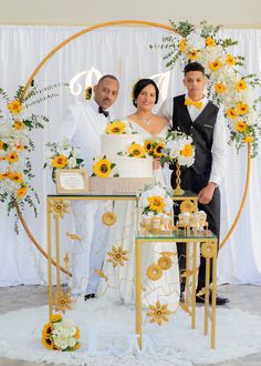 a man and woman standing in front of a cake with sunflowers on it